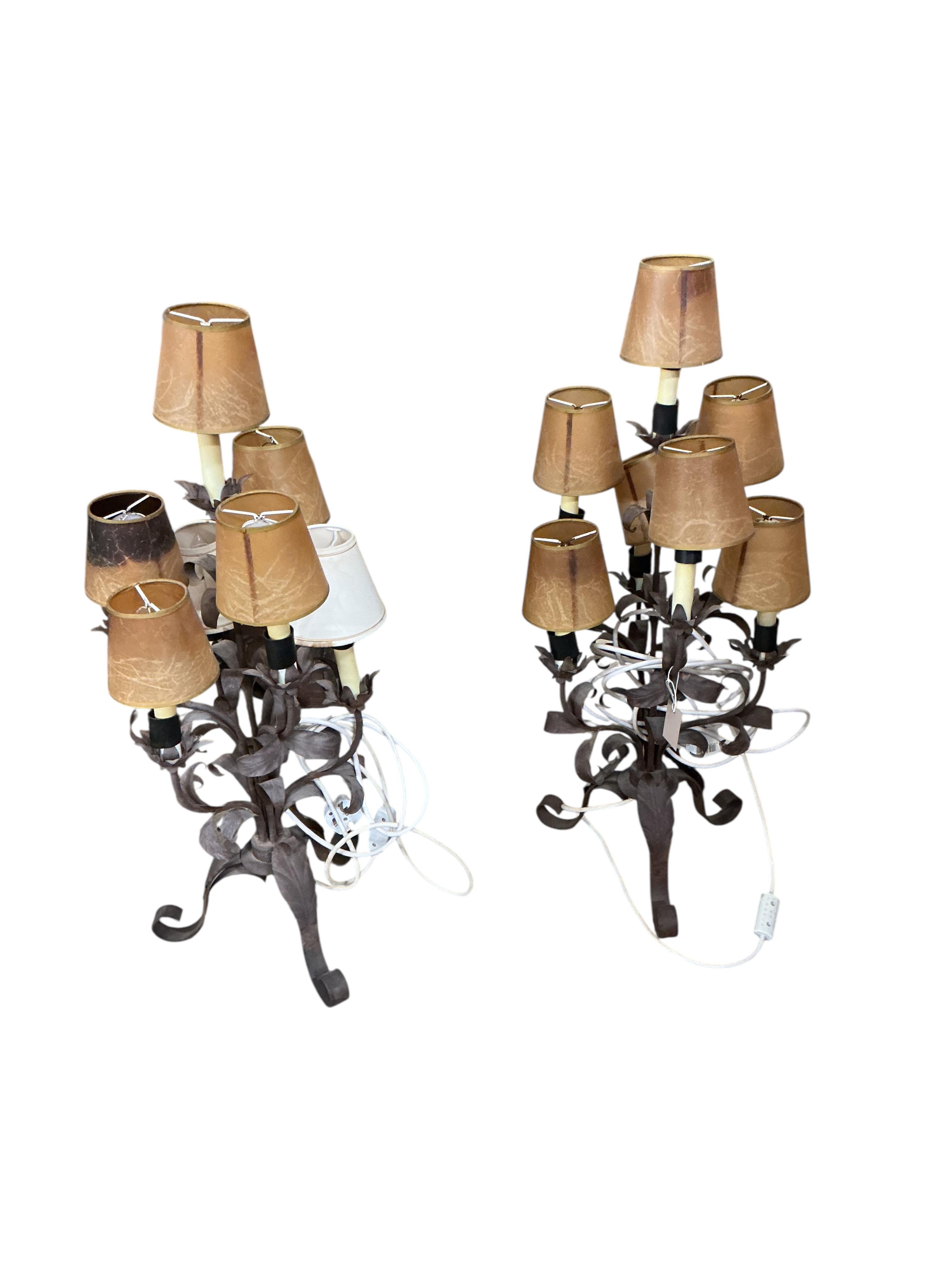 A pair of wrought and embossed four branch, five light candelabra, height 94cm